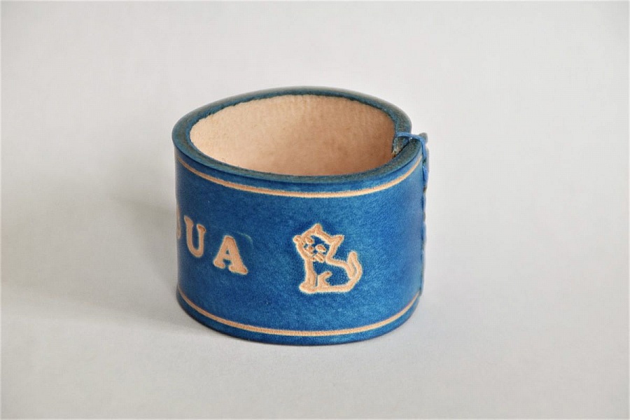 Bracelet en cuir bleu gravé avec motif de chat.