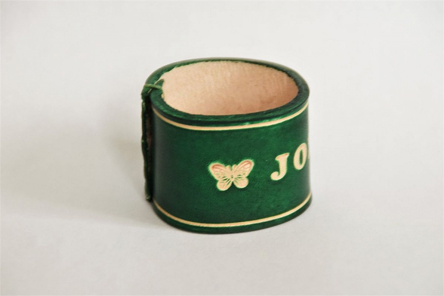 Bracelet en cuir vert personnalisé avec motif papillon gravé.