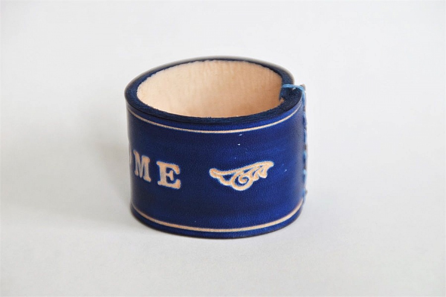 Bracelet en cuir bleu gravé avec motif ailé.